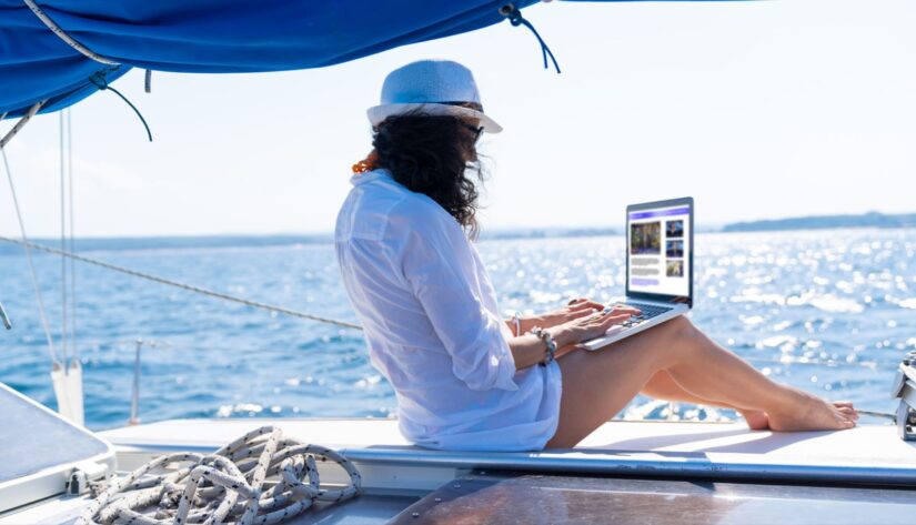 women working on laptop from yacht